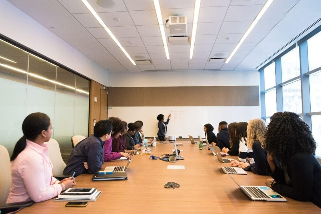 Reunião de um grupo de decisão B2B Uma apresentação para diferentes áreas ilustra como decisões B2B podem reunir critérios técnicos, financeiros e operacionais.